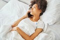 Bedridden woman making a phone call during the temperature measurement