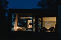 Bedroom in apartment or house with reflection in window glass of night forest.