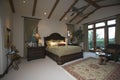 Bedroom With Beamed Ceiling And Patio Doors