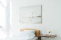 Bedroom with bed and flowers, bottles and glass on table Royalty Free Stock Photo