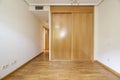 Bedroom with built-in wardrobe with sliding oak doors in a room with ducted air conditioning and French oak floors Royalty Free Stock Photo