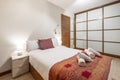 Bedroom with built-in wardrobe with wooden-framed sliding glass doors