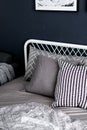 Bedroom corner setting with comfortable graphic pillows in neutral color with navy blue painted wall/ comfortable interior / inter Royalty Free Stock Photo