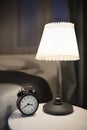 Bedroom detail with lamp and alarm clock, bedtime concept Royalty Free Stock Photo