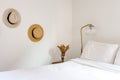 A bedroom detail shot with hats on the wall and a light on the nightstand.