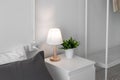 Bedroom detail shot with a light lamp and plant on the bedside minimal styles Royalty Free Stock Photo