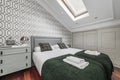 Bedroom with double bed with green cushions and blankets,