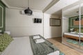 Bedroom with double bed with green cushions, green wall