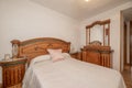 Bedroom with double bed with tacky wooden headboard in a room