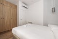 Bedroom with double bed with white bedding, wardrobe
