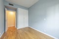 Bedroom of an empty house with laminated oak flooring with a white built-in wardrobe, ducted air conditioning and white carpentry Royalty Free Stock Photo