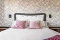 Bedroom headboard upholstered in gray and white satin fabric,