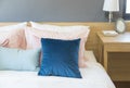 Bedroom interior with comfortable bed with pastel, blue and pink bedding Royalty Free Stock Photo