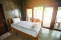 Bedroom interior design white and wooden bed - morning bedroom with sunlight and nature view on window , Loft room Royalty Free Stock Photo