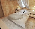 Bedroom interior in a log on the attic floor with a roof window. Royalty Free Stock Photo