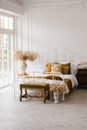 Bedroom interior, white bed with pillows and autumn decor, dried flowers in a vase Royalty Free Stock Photo