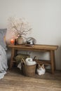 Bedroom interior with wooden bench, autumn decor, basket with blankets and a red cat under the bench Royalty Free Stock Photo