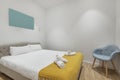 Bedroom with king size bed with white duvet, small yellow