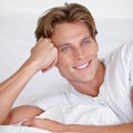 Bedroom, pillow and man relax in morning with happiness in home or lazy wake up after resting. Bed, smile and calm