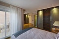 Bedroom in a room with a double bed with cushions, wooden bedside tables, built-in wooden and glass wardrobes, terrace with a