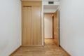 Bedroom with a small built-in wardrobe with sliding oak doors in a room with ducted air conditioning and French oak floors and an Royalty Free Stock Photo