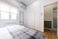 Bedroom with square wool blanket, window with roller blind, built-in wardrobe a Royalty Free Stock Photo