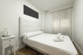 Bedroom with towels on the bed, white capitone upholstered