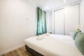 Bedroom with a two-section built-in wardrobe with white sliding doors, single beds together with trundles and green curtains