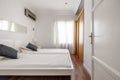 Bedroom with two white single beds, cherry wood sliding door wardrobe Royalty Free Stock Photo