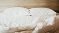 Bedroom with white bed, White two pillows, White duvet on the bed with wooden headboard and sunlight Royalty Free Stock Photo