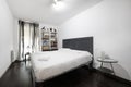 bedroom with white bookcase, window with gray curtains