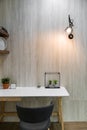 Bedroom working corner decorated with artificial plants and wall lamp with marble wall in the background /apartment interior