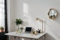 Bedroom working corner decorated with hexagon gold stainless vase and artificial plant in glass vase on gray spray-painted working