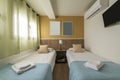 Bedroom with youth beds with blue bedspreads, green curtains,