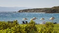 Beds and Straw Umbrellas On A Beach By Grape Vines At Bozcaada,