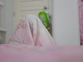 Bedsheet covering a little baby who enjoys playing / hiding herself - allowing children to use their creativity by playing with