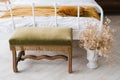 Bedside stool and dried flowers in a vase near the bed in the bedroom Royalty Free Stock Photo