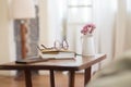 Bedside table with eyeglasses, books, flowers and phone on it Royalty Free Stock Photo