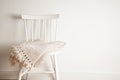 Bedspread or blanket on white vintage chair, minimalistic style. Housekeeping. Copy space. Royalty Free Stock Photo