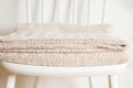 Bedspread or blanket on white vintage chair, minimalistic style. Housekeeping. Copy space. Royalty Free Stock Photo