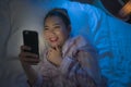 Bedtime lifestyle high angle portrait of young beautiful and happy sweet Asian Chinese woman in headband and pajamas enjoying with