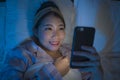 Bedtime lifestyle high angle portrait of young beautiful and happy sweet Asian Chinese woman with headband and pajamas enjoying
