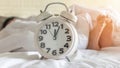 Bedtime sleep with alarm clock at noon or midnight time on bed in bedroom for world lazy day and healthy resting life balance Royalty Free Stock Photo