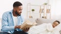 Bedtime story. Caring father reading book to sleeping daughter Royalty Free Stock Photo