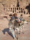 Beduin leaning against his donkey in Petra Jordan