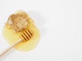 Bee honeycomb, honey dipper and a drop of honey on a white table top view. Flat lay, copy space