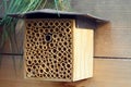 A bee house made of wood on a fence in the garden, a handmade beehive made of bamboo tubes. Careful attitude to nature