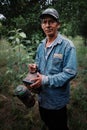 bee keeper and proud coffee farm owner preparing to harvest one of his hive with pumping smoke spray