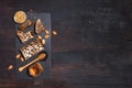 Bee pollen granules, honey jar with wooden dropper, honeycomb and almond nuts on black slate tray over dark backdrop. Copy space.