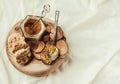 bee pollen in a jar on a wooden stand, Ceylon cinnamon and biscuits, white linen tablecloth background.Copy space.Top view.